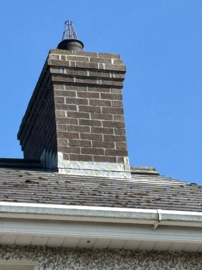 Brick chimney stack with cowl on Dublin roof