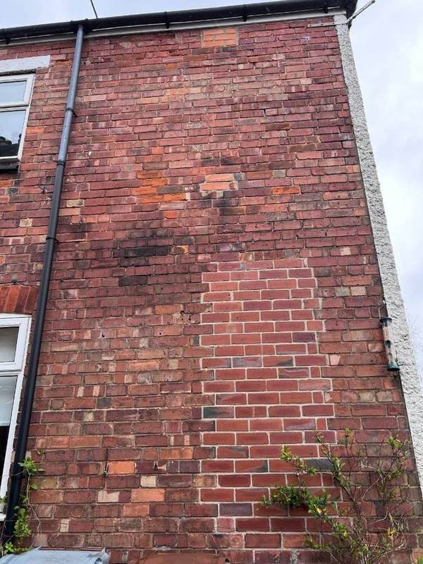 Repaired brick panel on weathered wall